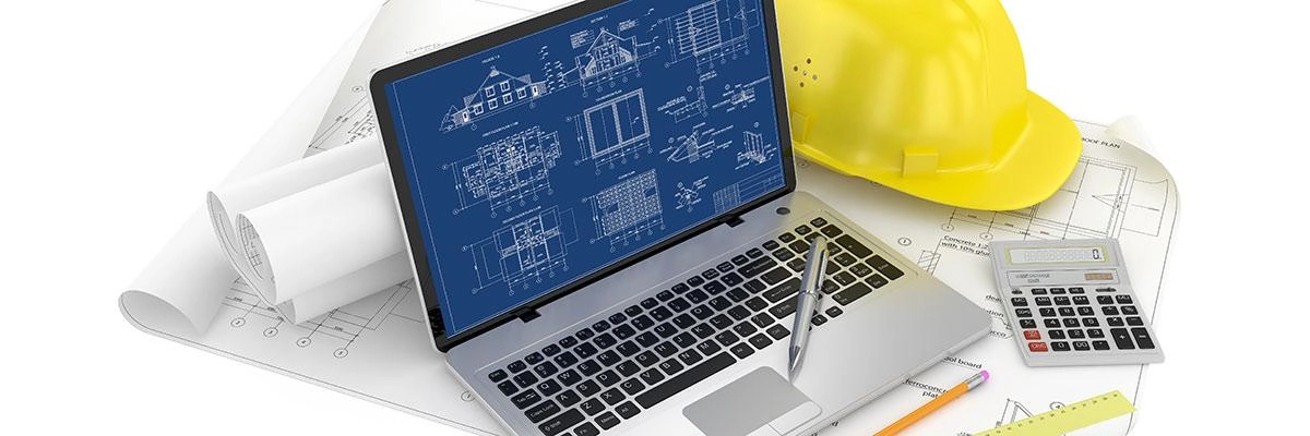 A computer sits next to a calculator and some building plans. The computer screen shows the plans being quantified and the building costs estimated.